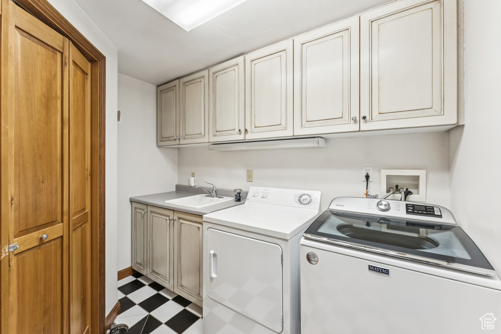 Washroom featuring cabinet space, washer and dryer, and tile patterned floors
