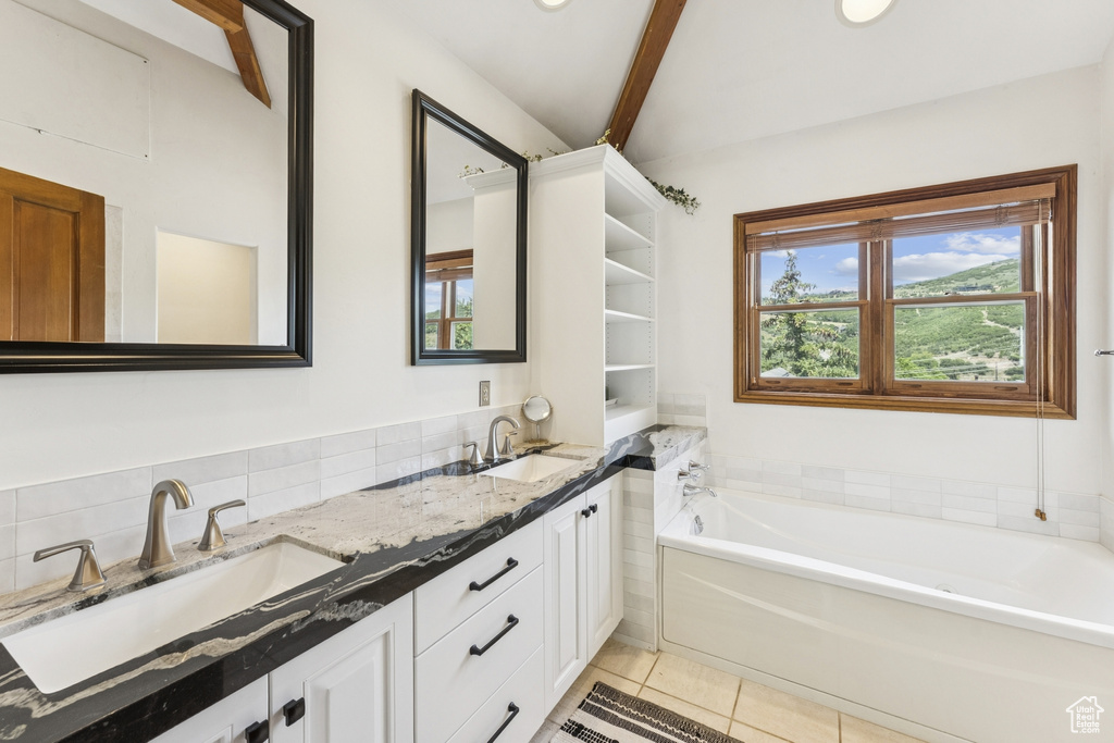 Full bath with double vanity, a bath, tile patterned flooring, beamed ceiling, and tasteful backsplash