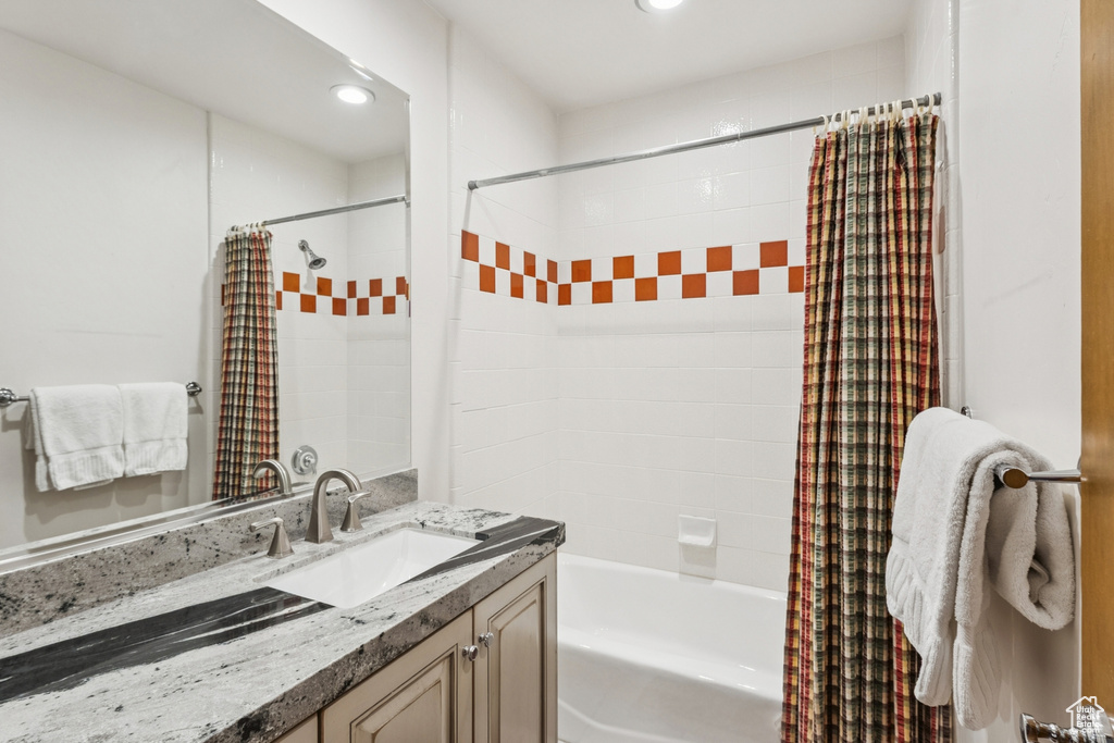 Bathroom featuring vanity, shower / tub combo, and recessed lighting