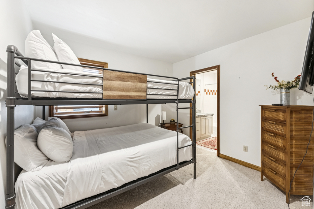 Bedroom with light carpet and ensuite bath