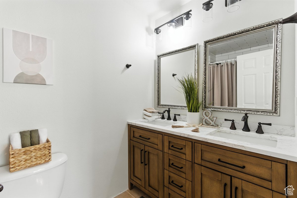 Bathroom featuring toilet and double vanity