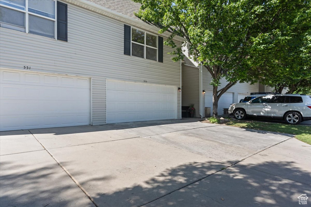 View of side of home with an attached garage and concrete driveway