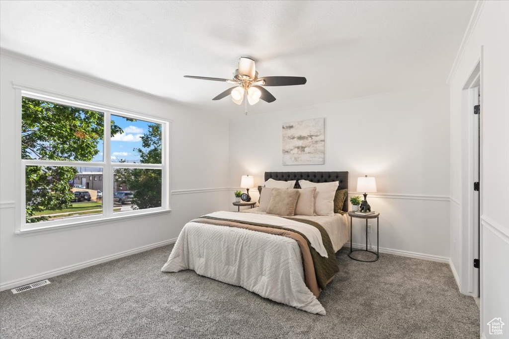 Carpeted bedroom with baseboards and a ceiling fan