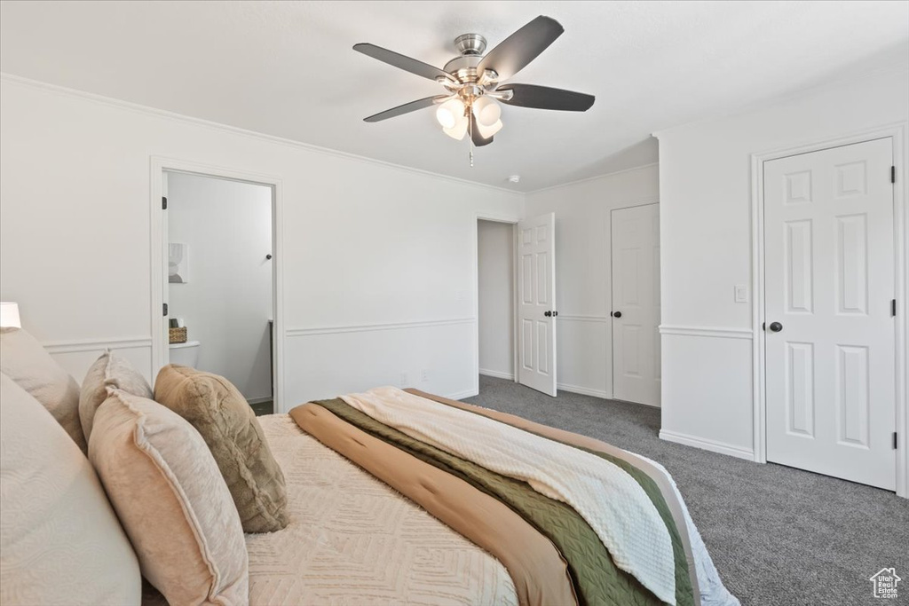 Carpeted bedroom with ornamental molding, ceiling fan, and ensuite bathroom