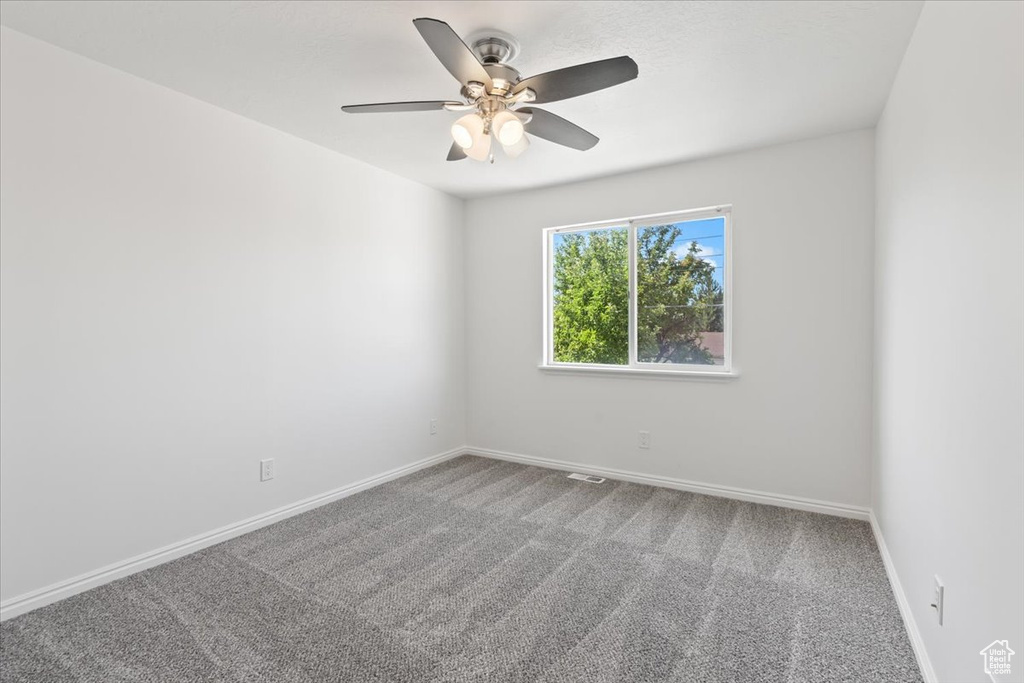 Unfurnished room with carpet floors and a ceiling fan