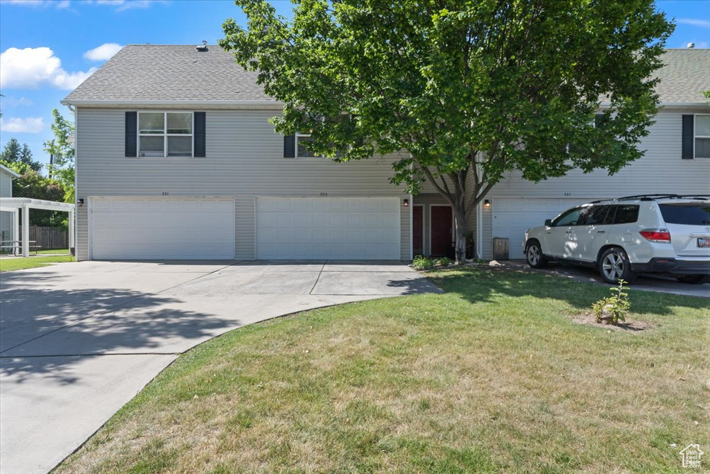 View of front of house with driveway, a garage, a front lawn, and roof with shingles