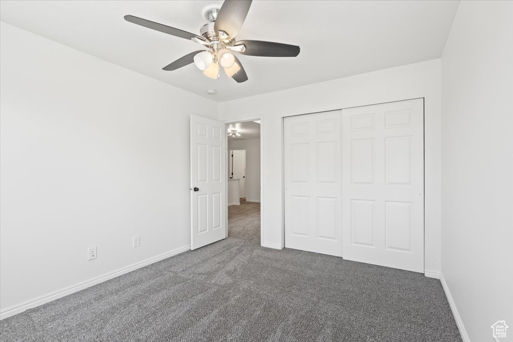 Unfurnished bedroom featuring carpet floors, a closet, and a ceiling fan