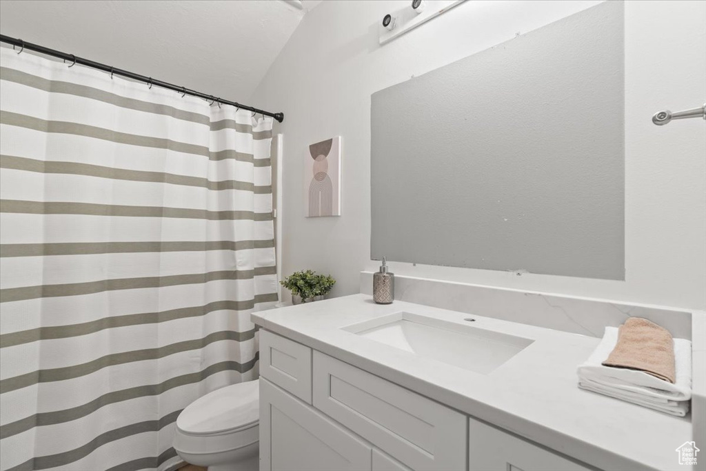 Full bathroom with vanity, curtained shower, and vaulted ceiling