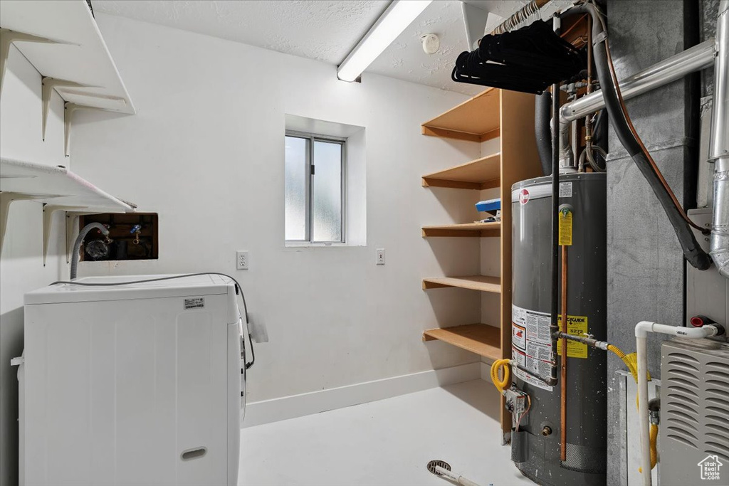 Below grade area featuring washer / dryer and water heater