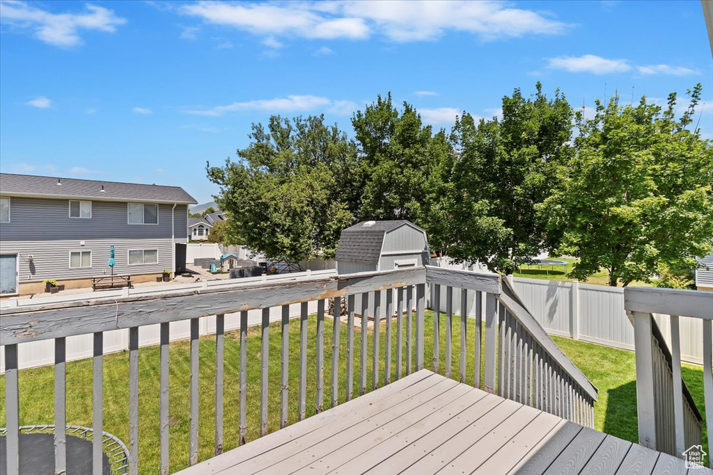 Wooden deck with a fenced backyard and a storage unit