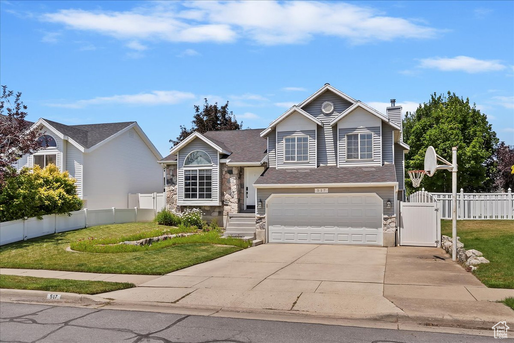 View of front of home featuring stone siding, concrete driveway, a garage, a gate, and a chimney