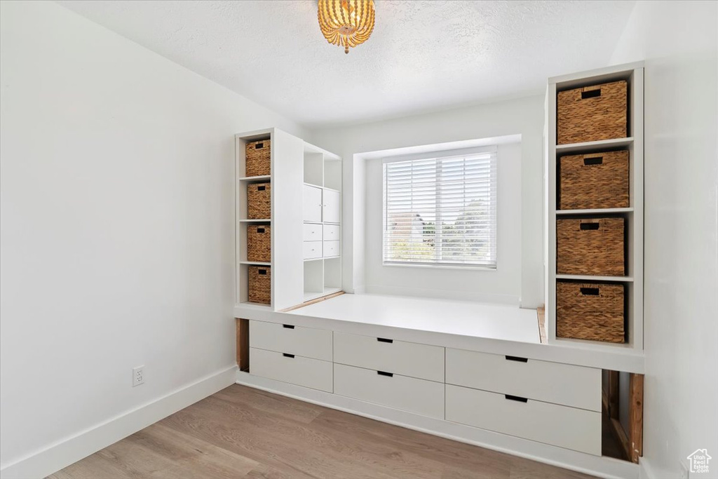 Mudroom featuring light wood finished floors and a textured ceiling