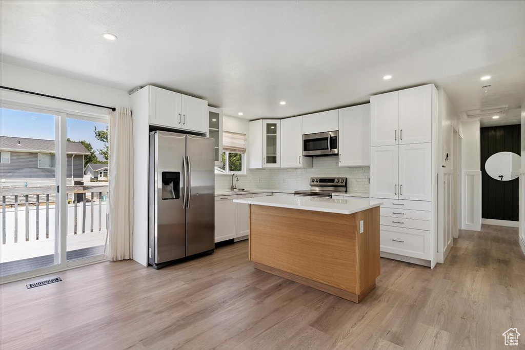 Kitchen with stainless steel appliances, light countertops, decorative backsplash, plenty of natural light, and recessed lighting