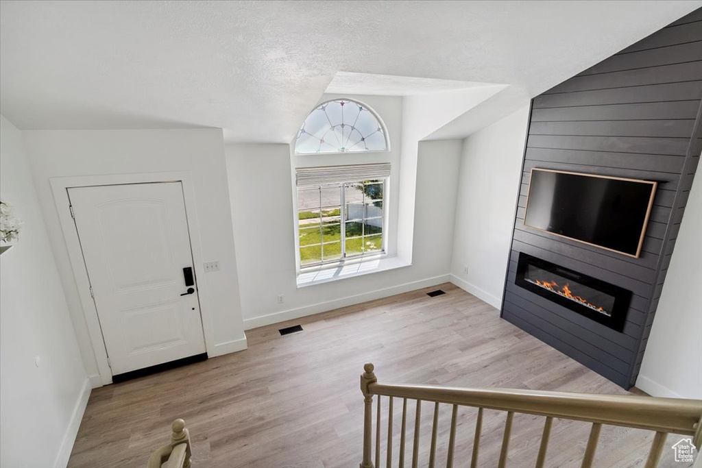 Foyer entrance featuring a fireplace and wood finished floors