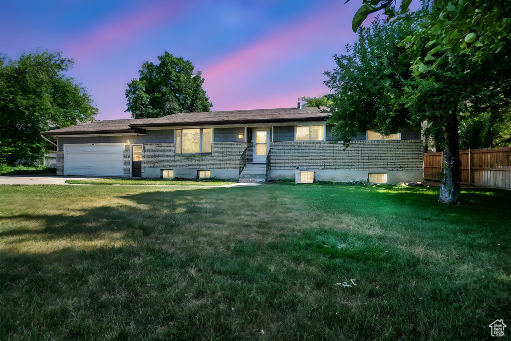Ranch-style house featuring a garage, brick siding, and driveway