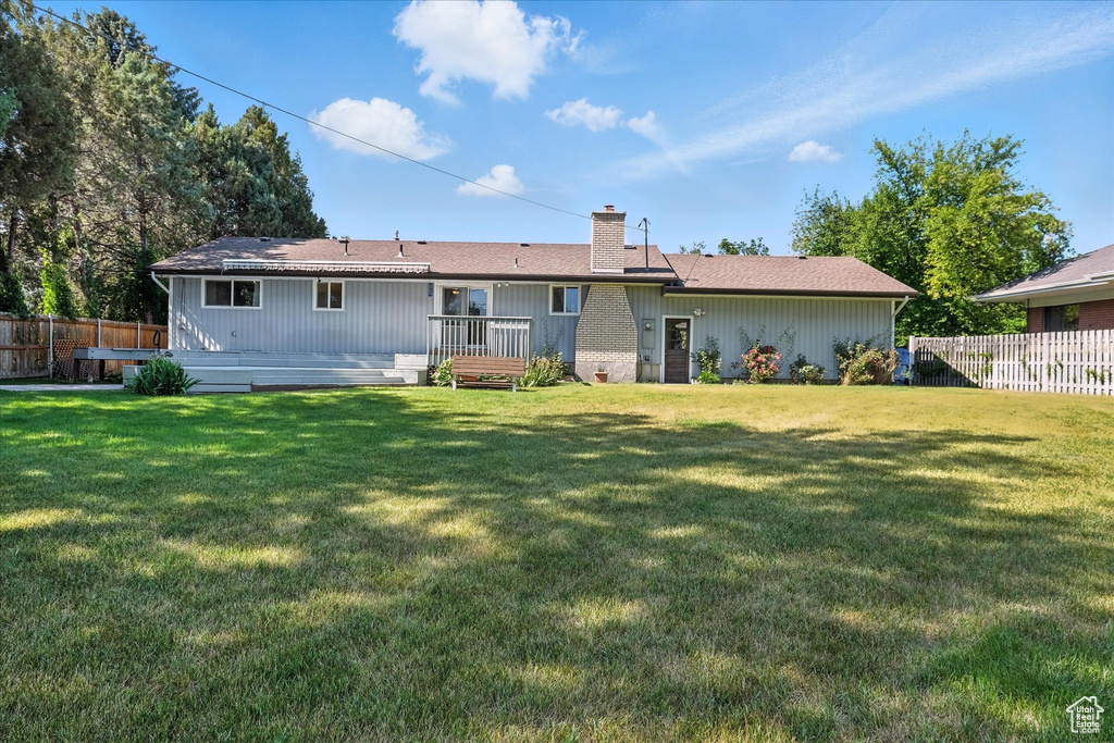 Rear view of property with a chimney and a wooden deck