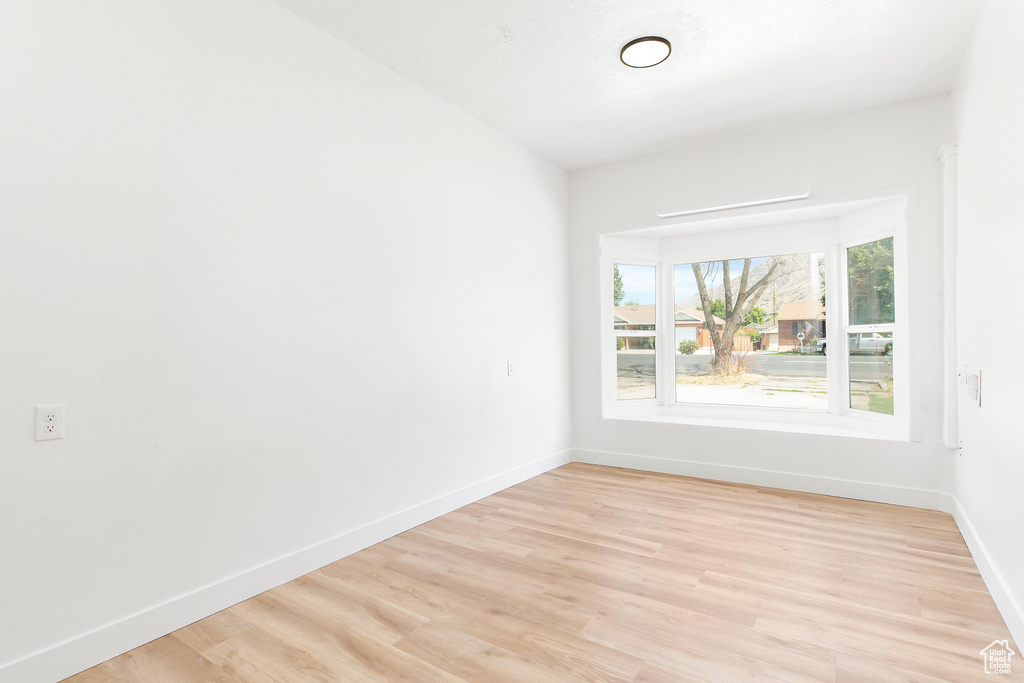 Spare room with light wood-type flooring and baseboards