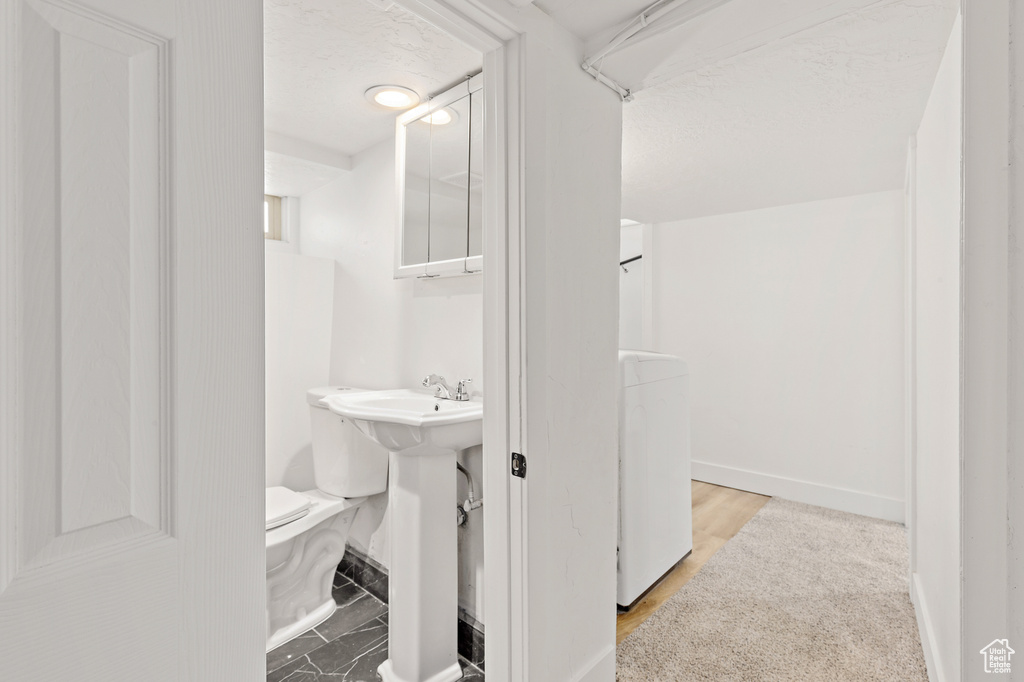 Bathroom featuring washer / clothes dryer and toilet