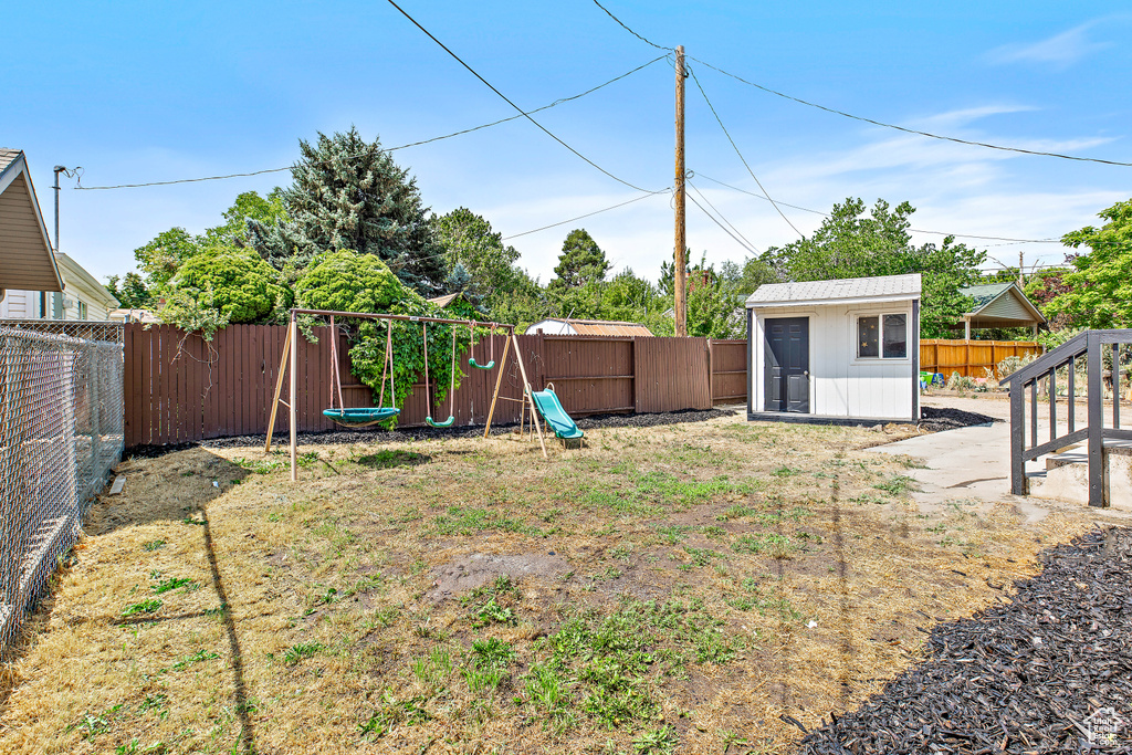 Fenced backyard featuring a storage unit