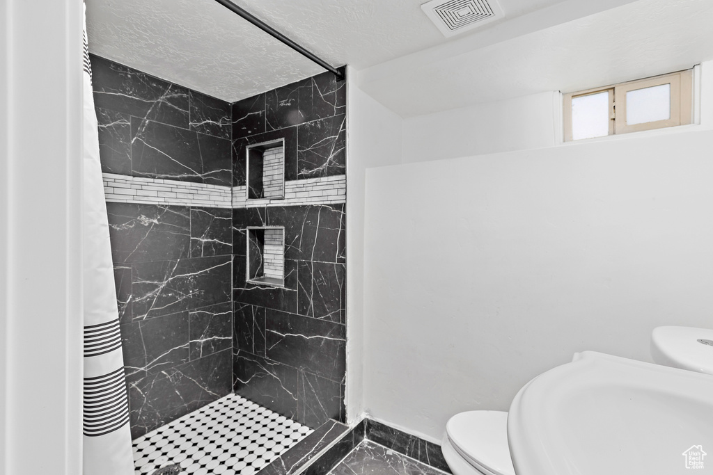 Bathroom featuring marble finish flooring and a shower stall