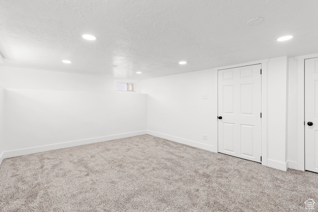 Below grade area with carpet, recessed lighting, and a textured ceiling