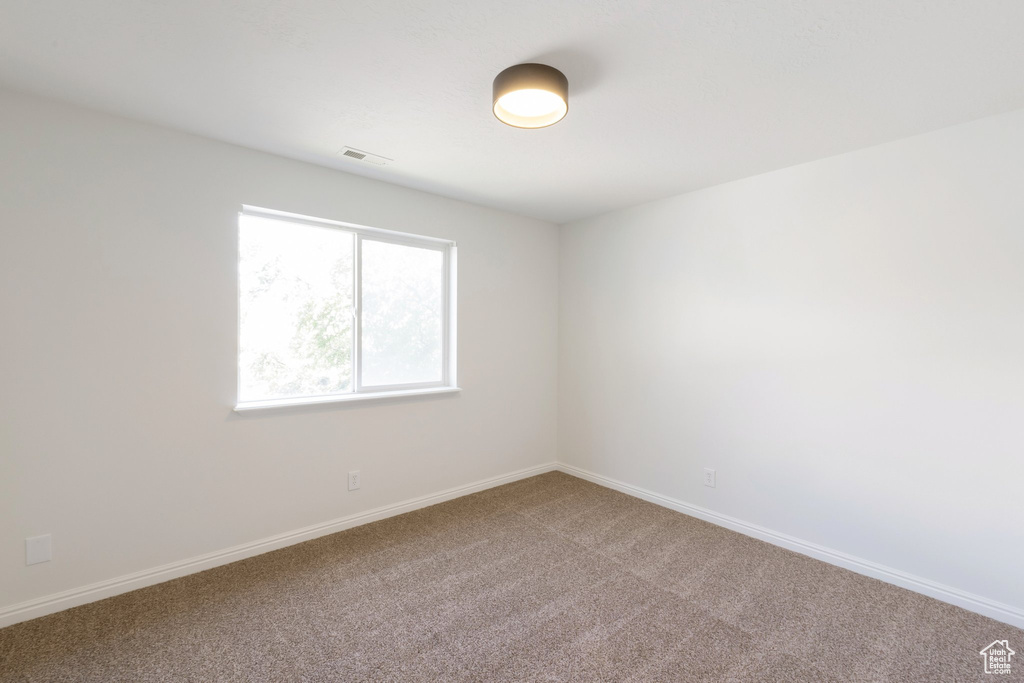 Empty room with carpet and baseboards