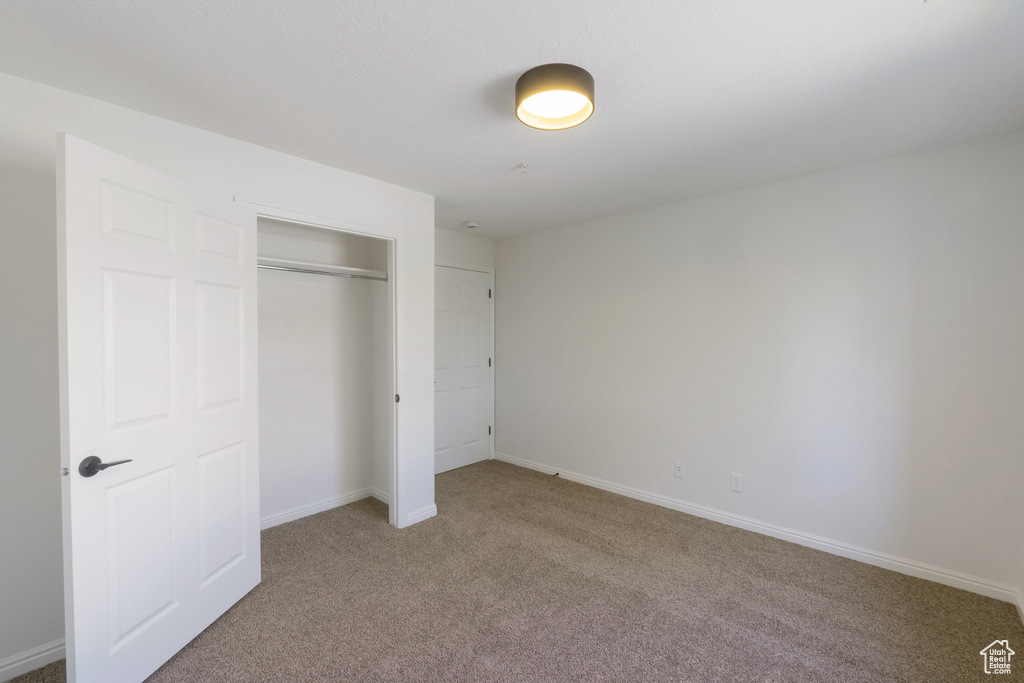 Unfurnished bedroom with carpet and a closet