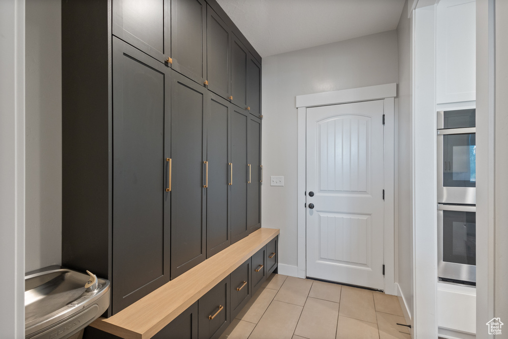 Mudroom with light tile patterned floors and baseboards