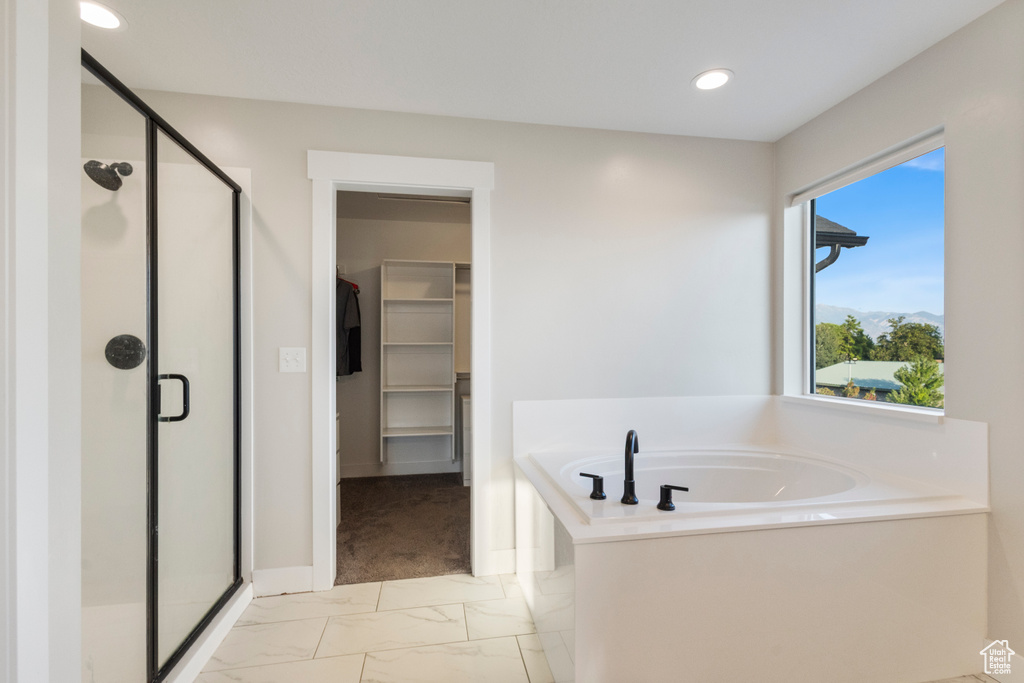 Full bath featuring a shower stall, marble finish floors, a bath, a walk in closet, and recessed lighting