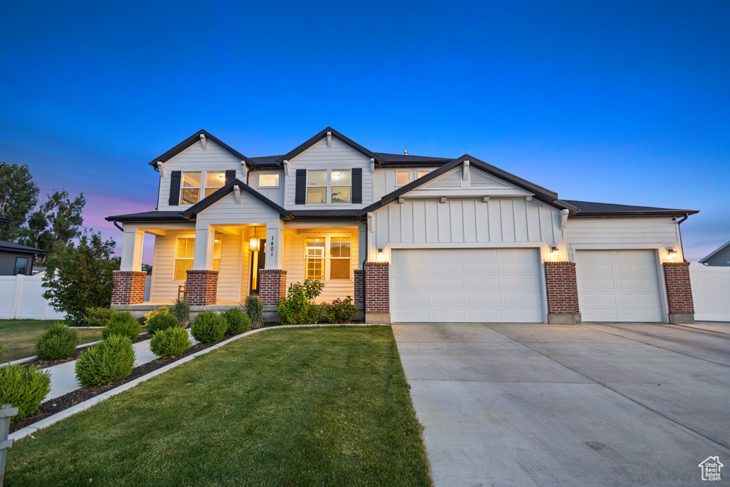 View of front of house with concrete driveway, covered porch, a garage, board and batten siding, and brick siding