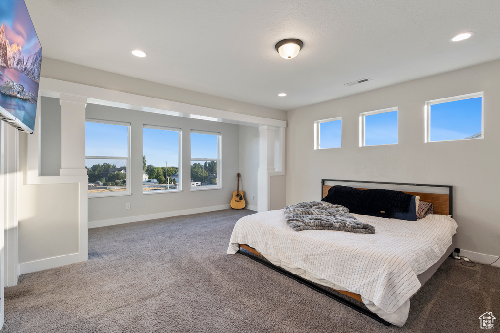 Bedroom with carpet flooring, recessed lighting, and decorative columns