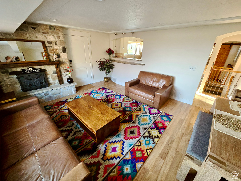 Living room featuring a stone fireplace and wood finished floors