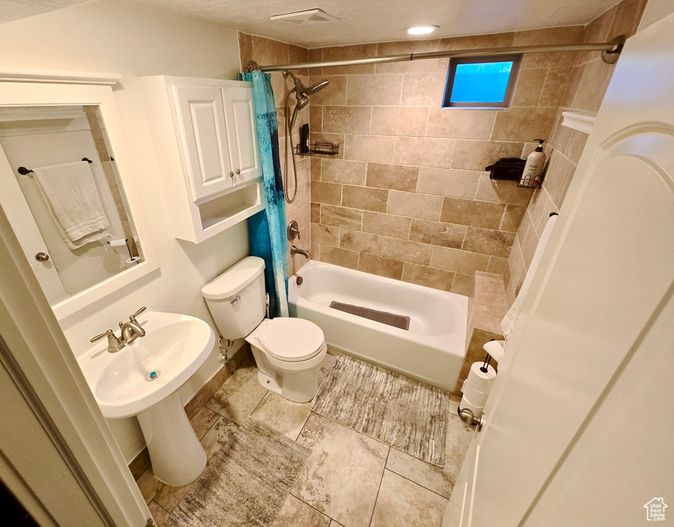 Full bath featuring shower / bathtub combination with curtain and tile patterned flooring