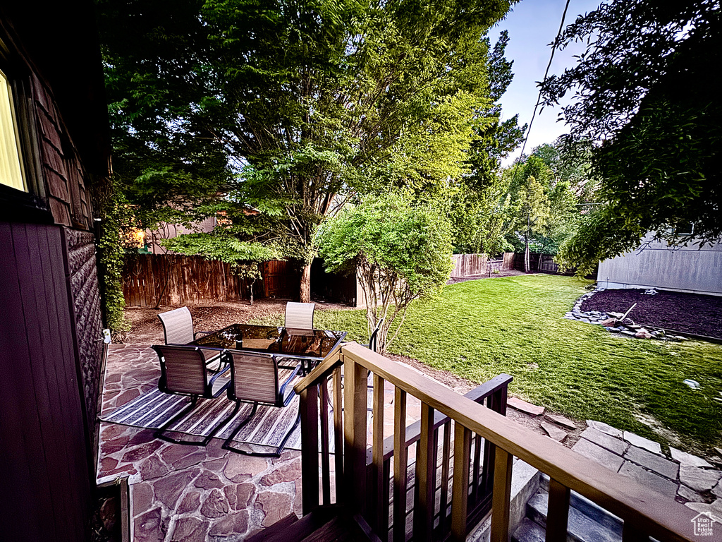Wooden terrace with a fenced backyard and a patio area