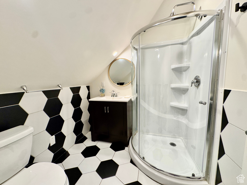 Bathroom with vanity, a shower stall, and tile patterned flooring