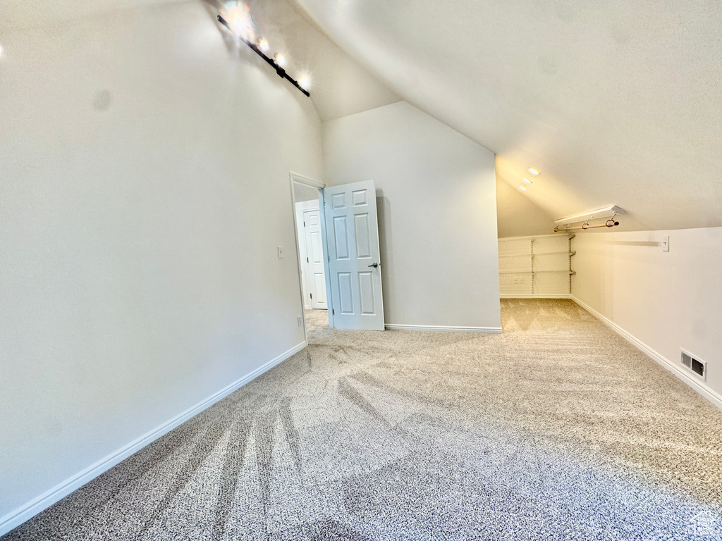 Additional living space featuring lofted ceiling and carpet floors