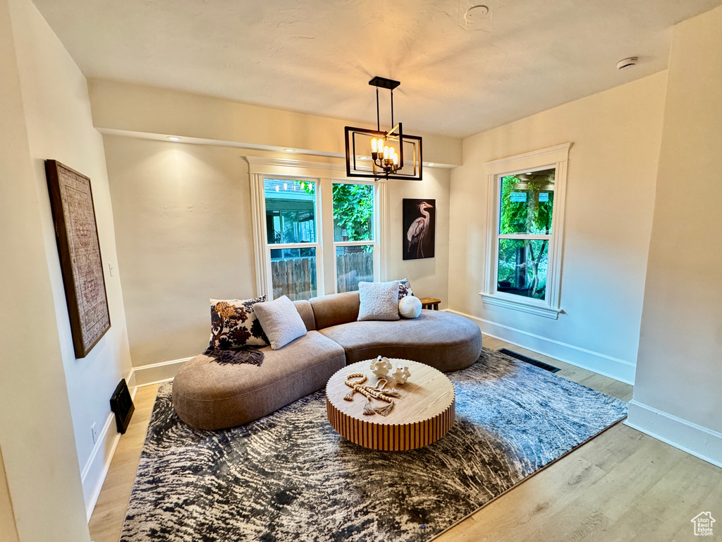 Living room featuring light wood-style floors and a chandelier