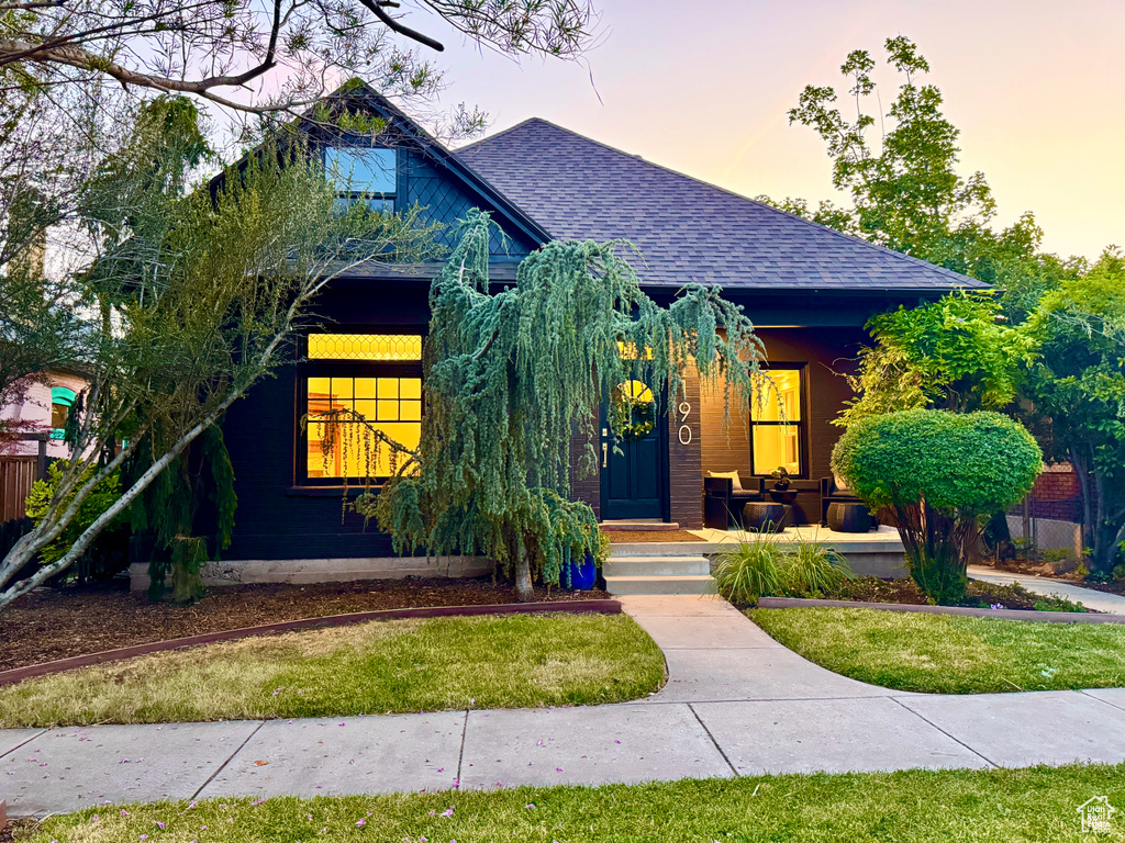 View of front of house featuring roof with shingles and a porch