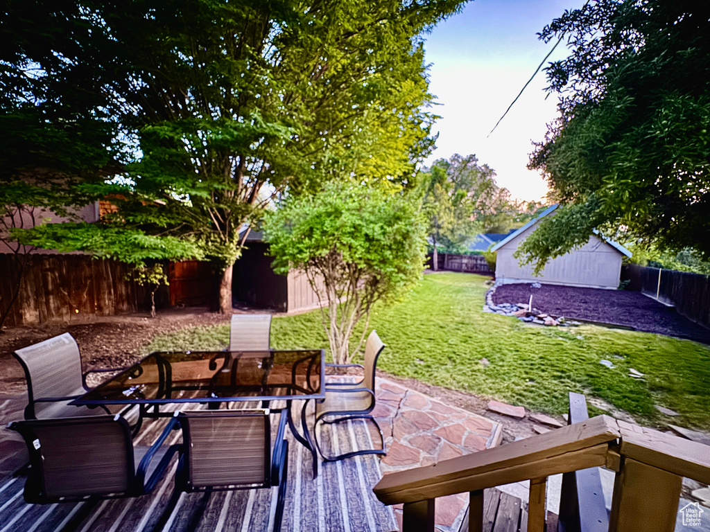 Fenced backyard with an outdoor structure, outdoor dining space, and a patio area