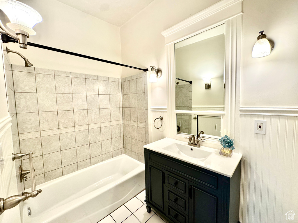 Full bath with wainscoting, bathing tub / shower combination, vanity, and tile patterned flooring
