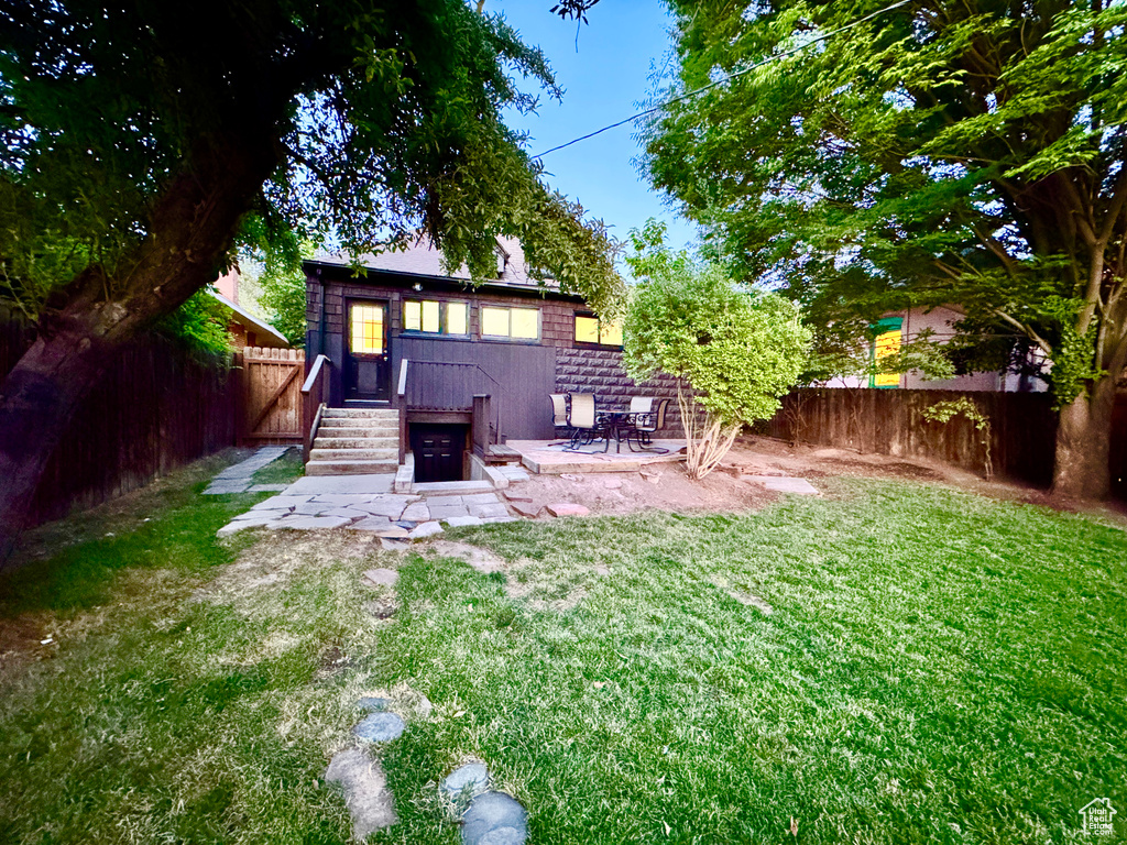 Rear view of property with a fenced backyard and a patio area