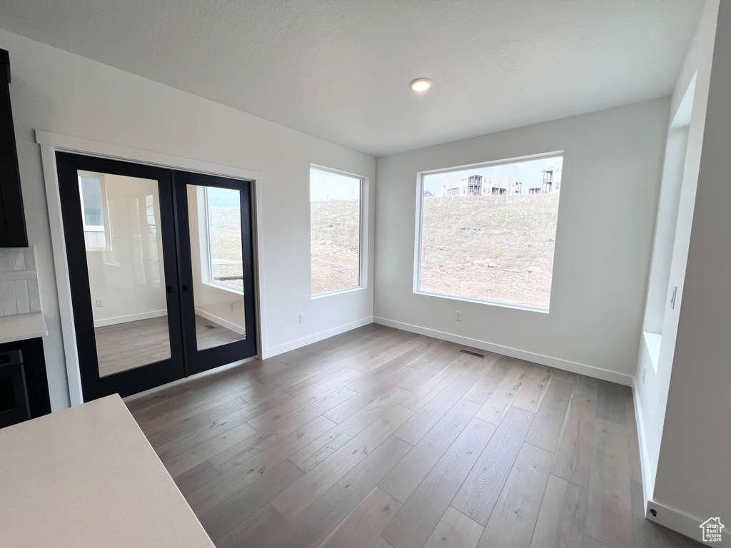 Unfurnished room with french doors, wood finished floors, and recessed lighting