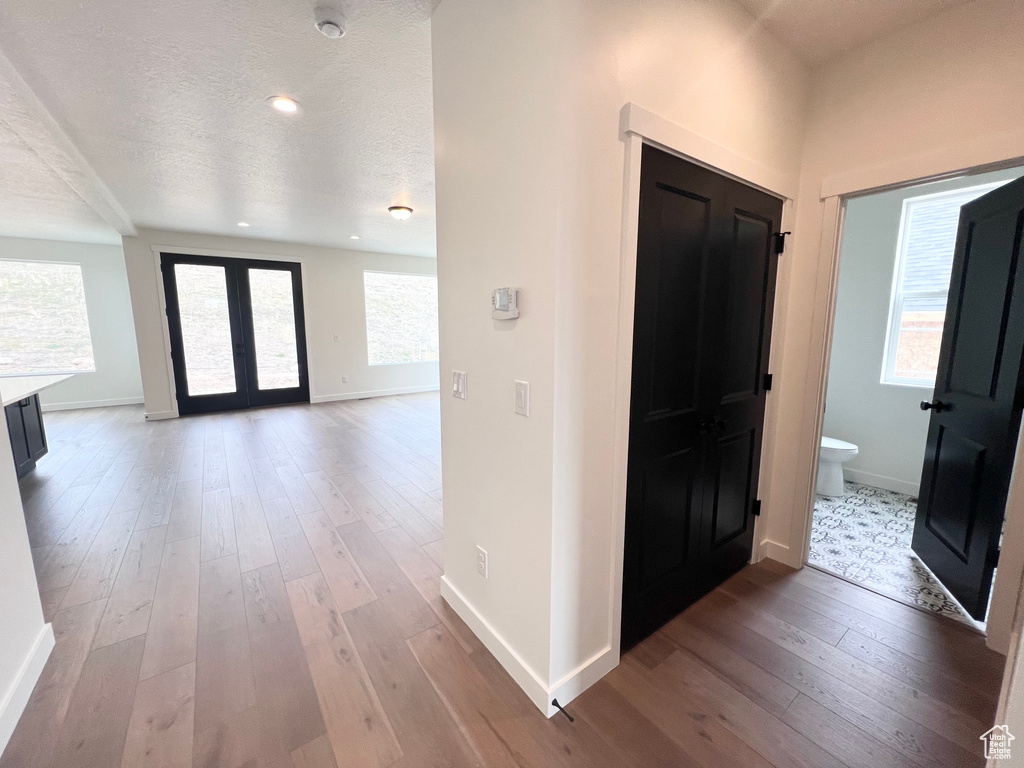 Foyer entrance with hardwood / wood-style flooring, french doors, a textured ceiling, and recessed lighting