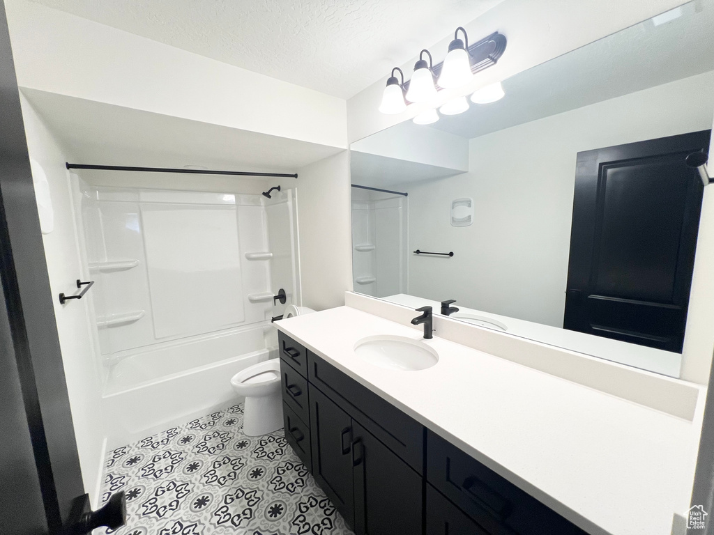 Full bathroom featuring vanity, shower / washtub combination, tile patterned floors, and a textured ceiling