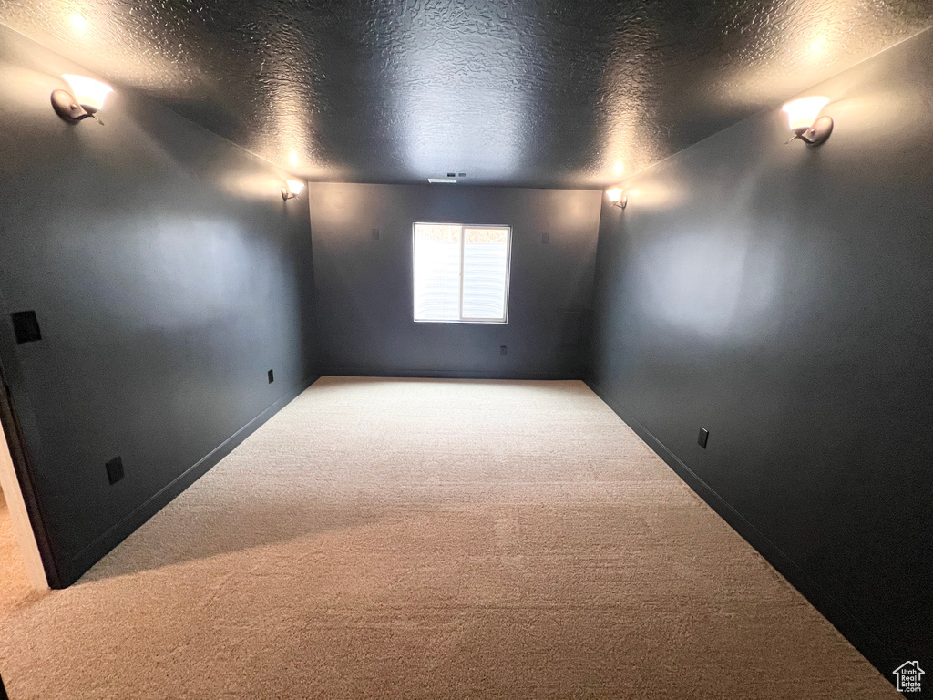 Empty room featuring carpet flooring and a textured ceiling