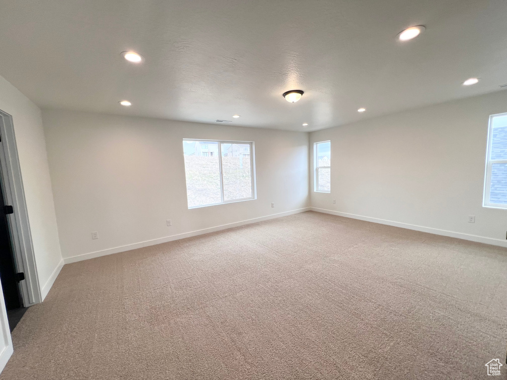 Empty room featuring recessed lighting and light colored carpet