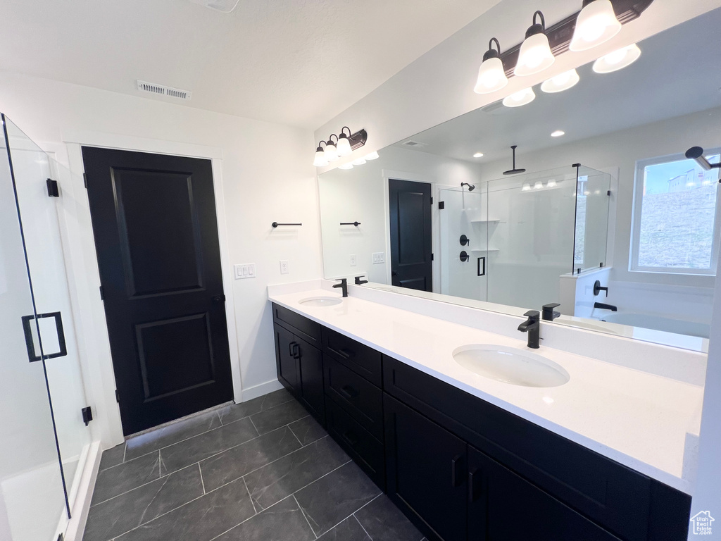 Full bathroom featuring a shower stall, double vanity, tile patterned floors, and a bath
