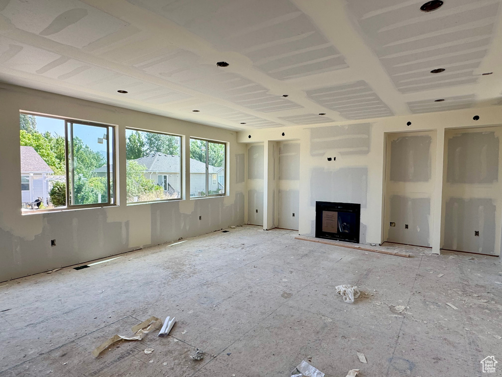 Unfurnished living room featuring a fireplace with raised hearth