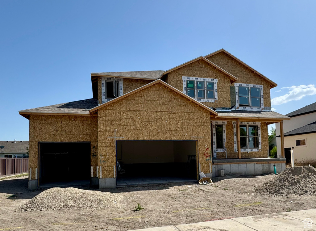 Property under construction with driveway and a shingled roof