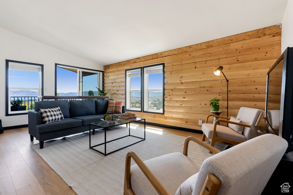 Living area featuring rustic walls, vaulted ceiling, and wood finished floors